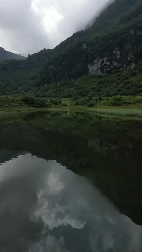 Vertical drone view of remote alpine lake in high mountain landscape Stock Footage 330750001