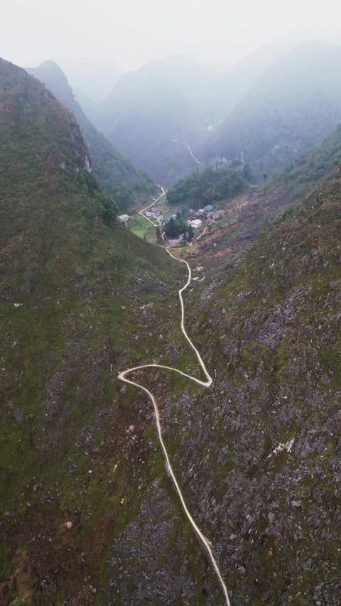 Vertical Drone View of Remote Mountain Settlement in a Fog Filled Valley with Vidéo 333814449