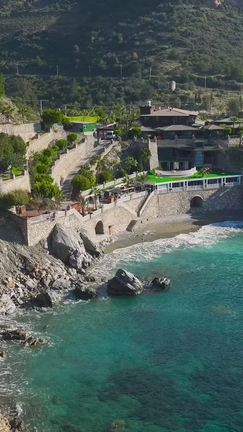 Vertical Drone View Seaside Villas Built on Rocky Cliff with Scenic Ocean Video stock 341705939