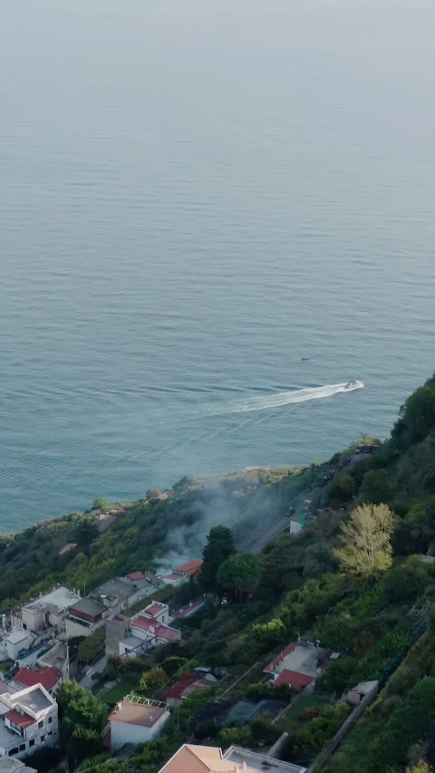 Vertical Drone View of Smoke Burning on a Steep Mountain Cliff near Residential Vídeos de archivo 331117985