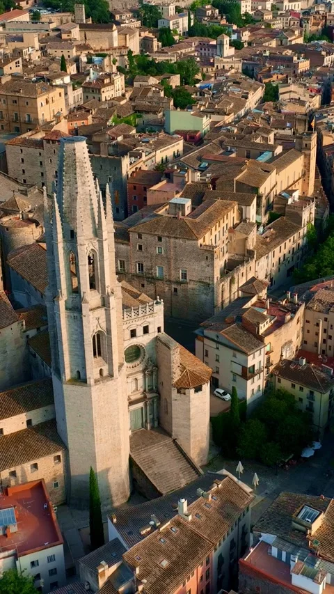 Vertical drone view of Spanish historic town of Girona at sunset, tourism in Stock Footage 280343907