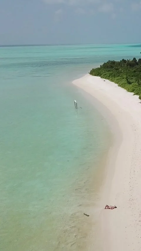 Vertical drone view of woman sunbathing on white sand beach in Faafu Atoll Stockbeeldmateriaal 344257136