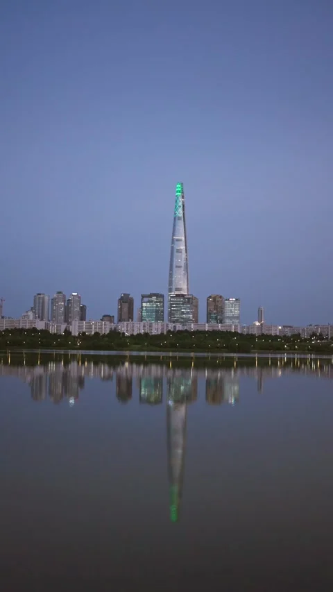 Vertical dusk skyline of Lotte Tower and reflection on river Stock Footage 314127273