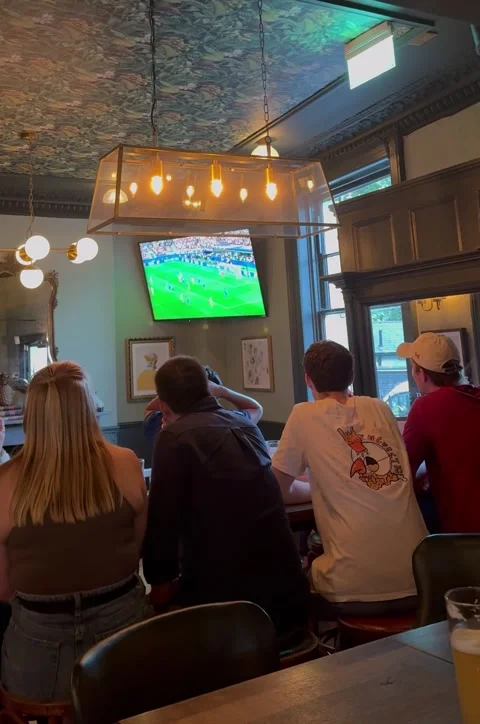 Vertical editorial shot of people watching football match in London pub Stock Footage 337160365