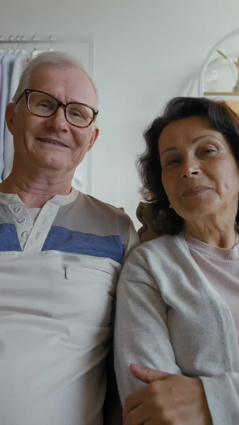 Vertical of Elderly couple sits on sofa at home talking on video call Stock Footage 276626641