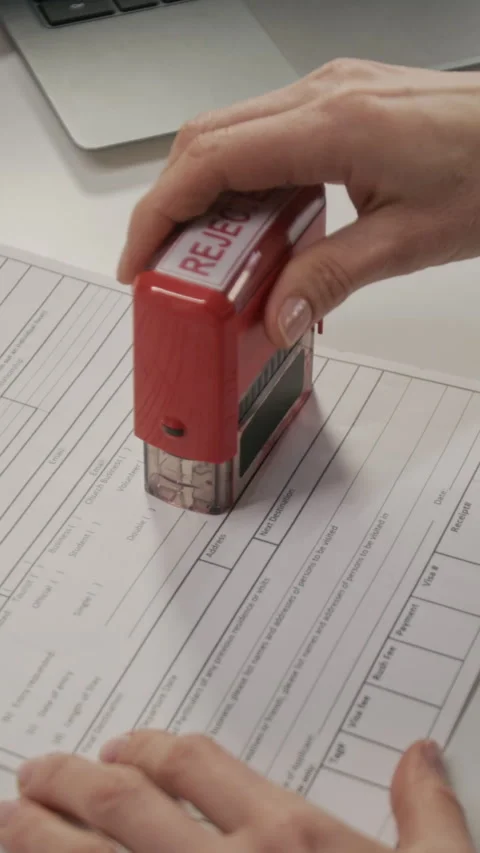 Vertical of Embassy Official Putting Rejected Stamp on Tourist Visa Application Stock Footage 331519167