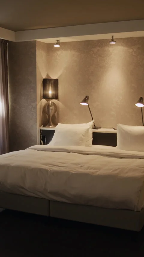 Vertical of Empty Hotel Room Featuring Comfortable Bed with Linens Stock Footage 336076275