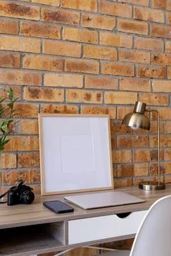 Vertical of empty wooden frame with copy space, plants and technology on desk Stock Photos