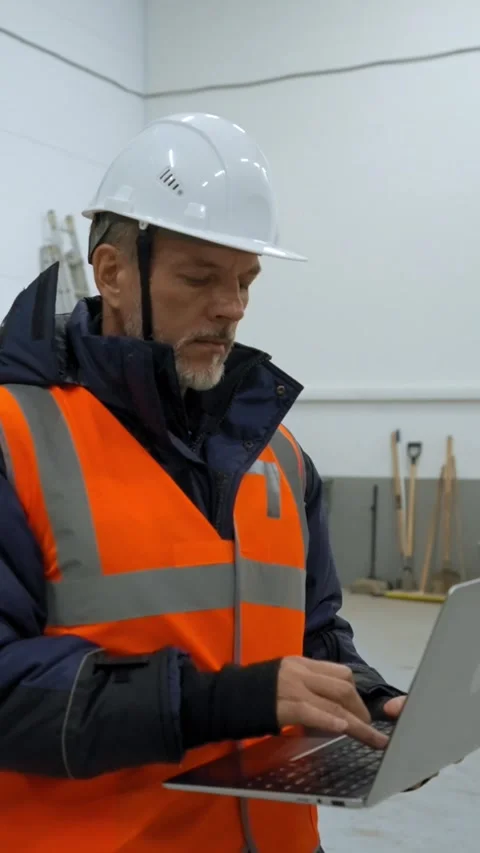 Vertical of Engineer examines premise of warehouse holding laptop Stock Footage 275624244