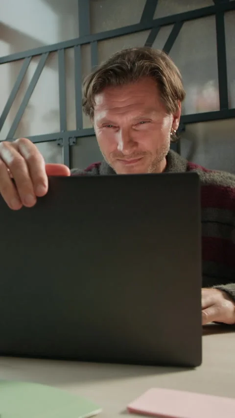 Vertical of Exhausted Male Programmer Opening Laptop at Workplace Video stock 319992824