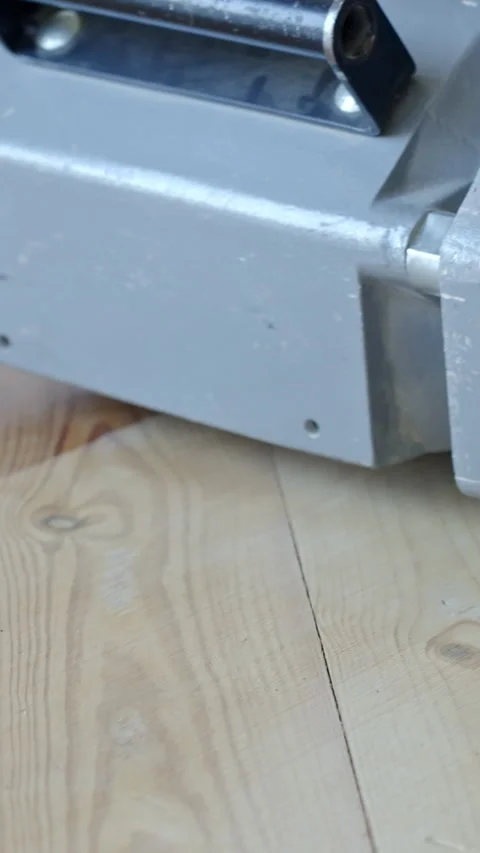 Vertical extreme close-up of floor sander moving backwards over pine planks 스톡 동영상 310588545
