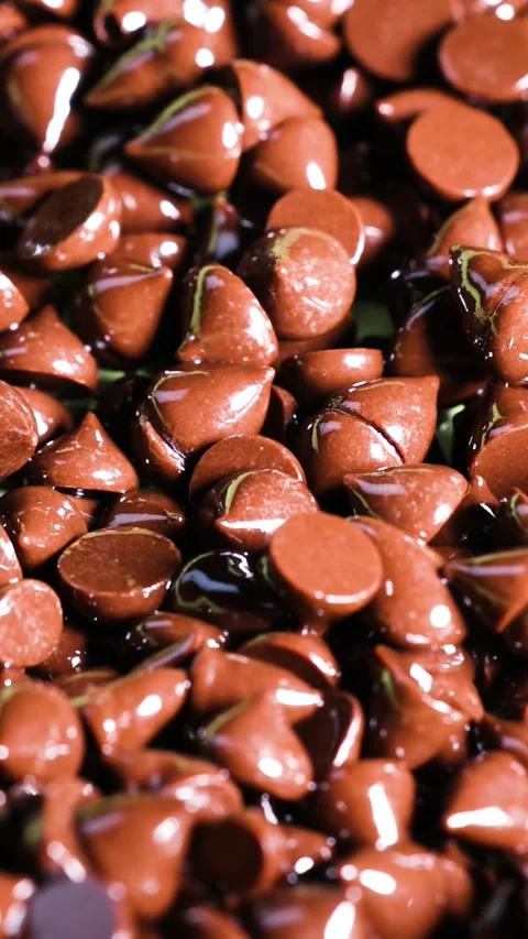 Vertical Extreme Close Up of Shiny Milk Chocolate Chips Background Stock Footage 326876316