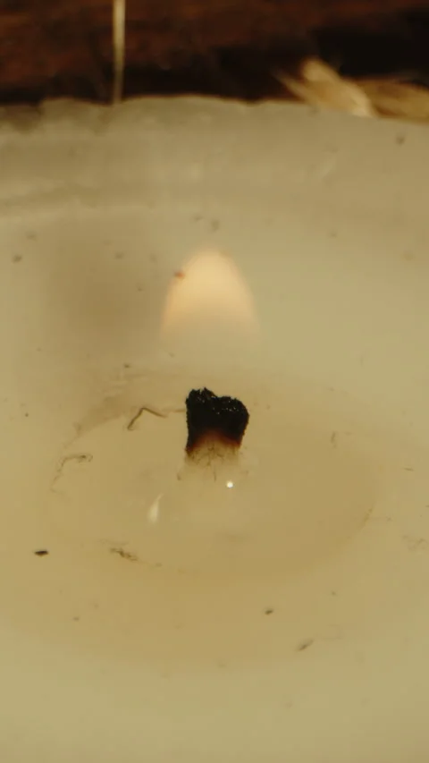 Vertical extreme close up of a small flame burning on a candle Video stock 336369070