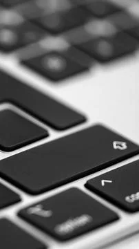 Vertical extreme close up view of a modern black laptop keyboard keys with .. Stock Photos