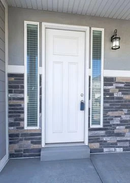 Vertical Facade of a front door with two side panels and window Stock Photos