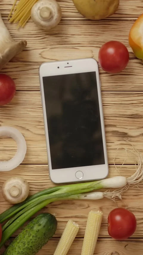 Vertical of Faceless cook putting smartphone on table with vegetables Stock Footage 276806561