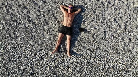 Vertical fast motion from man on beach to aerial coast view Video stock 103181929