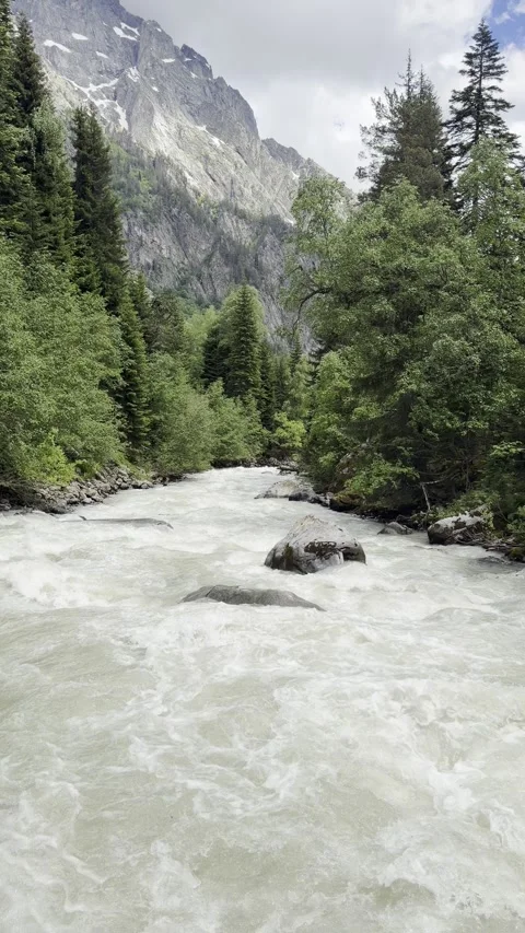 Vertical fast mountain river with snow-capped peak, Georgia Stock Footage 345966393