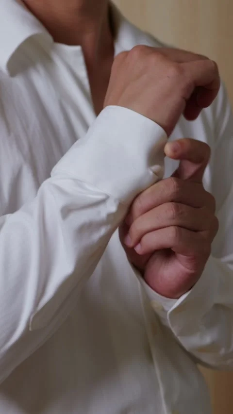 Vertical: Fastening cuff buttons on a white shirt. Stock Footage 345459228