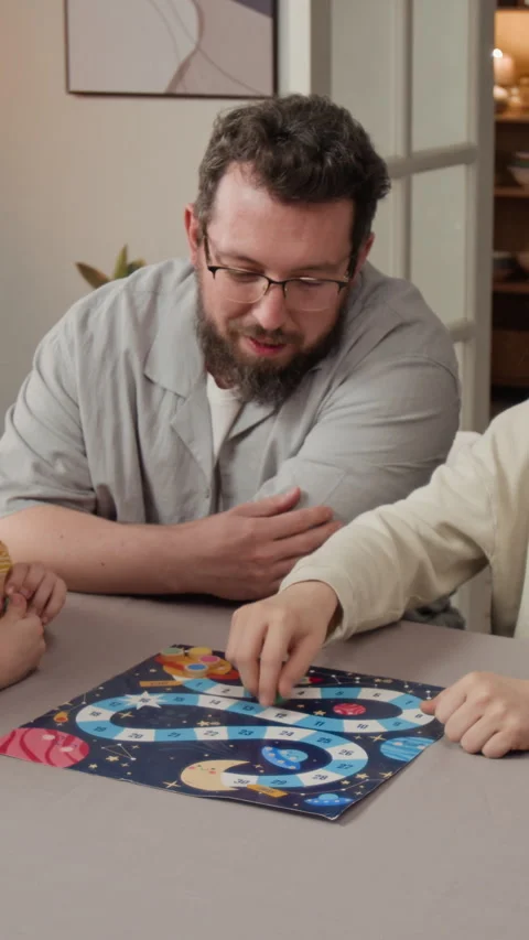 Vertical of Father and Children Playing Educational Board Game at Home Stock Footage 340323932
