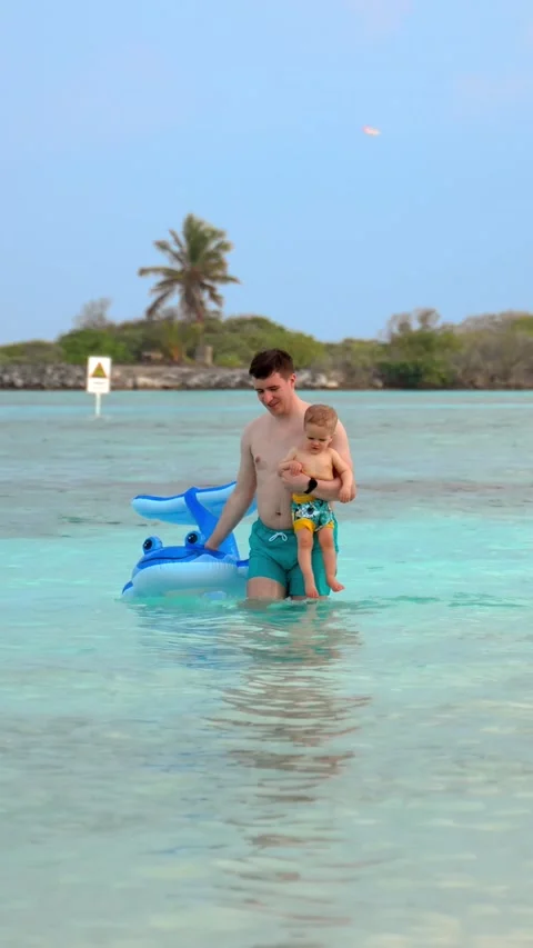 Vertical of Father and son bathed in the ocean and went ashore Stock Footage 275640947