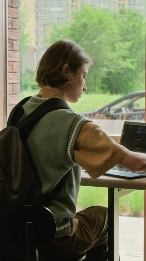 Vertical of Female Freelancer Working on Laptop by Window in Coworking Space Stock Footage 342112335