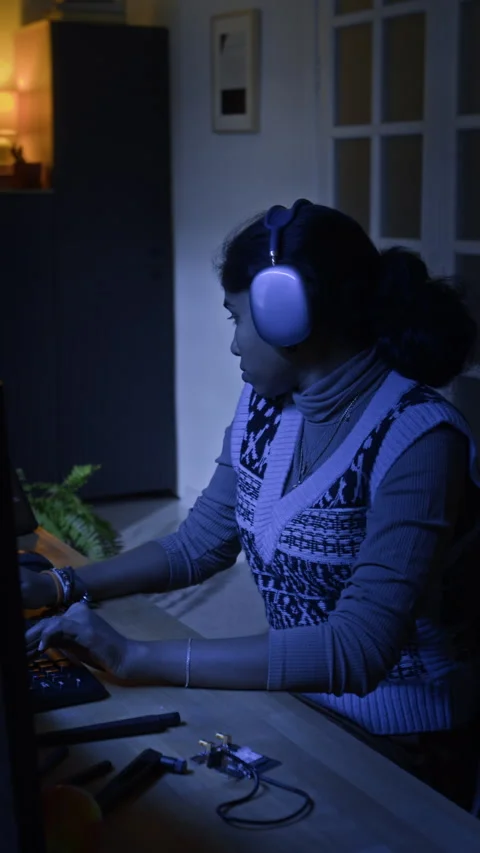 Vertical of Female Hacker with Headphones Coding on Computer in Home Office Stock Footage 328249035