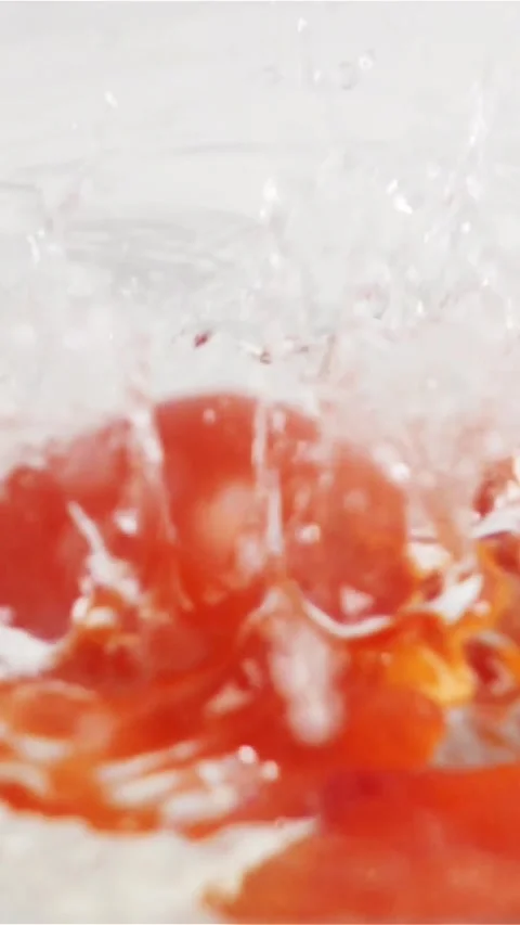 Vertical of Few red tomatoes falling down into water with splash Stock Footage 305516632