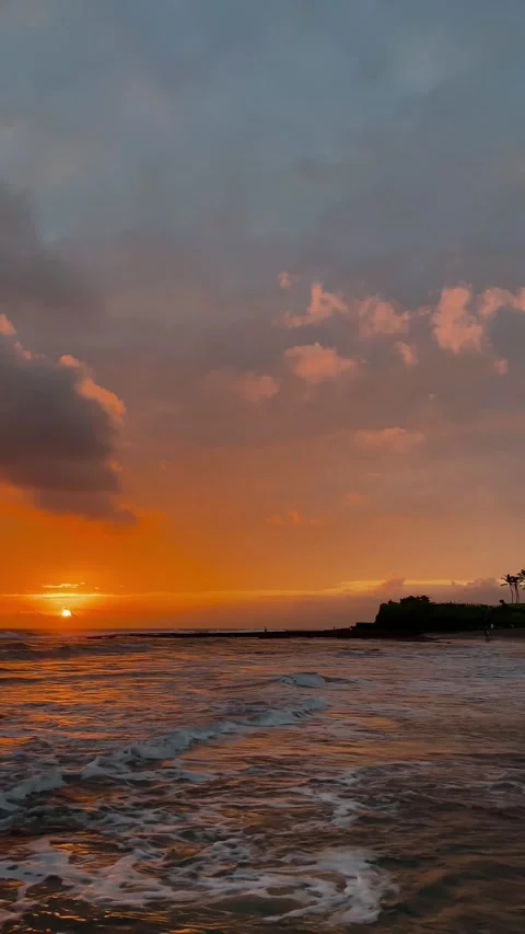 Vertical Fiery Sunset Ocean Waves with Temple Silhouette in Bali Stock Footage 337270351