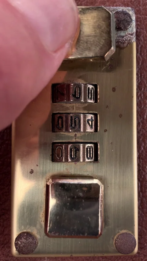 Vertical - Fingers closing the latch of a three number brass combination lock. Stock Footage 281578423