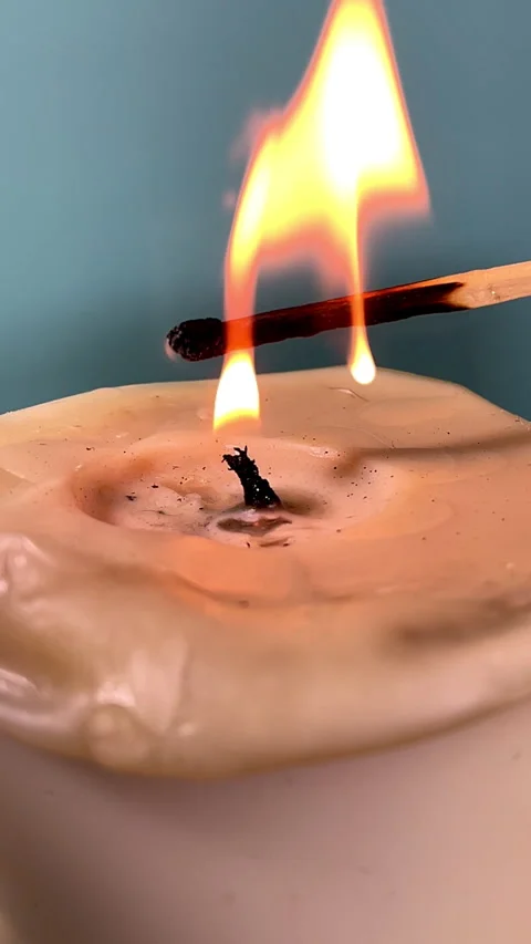 Vertical -  The flame from a matchstick lighting the wick of a wax candle. Stock Footage 288340529