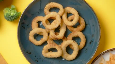 Vertical flat lay: chef puts plate with onion rings to the colorful background Stock Footage 180942835