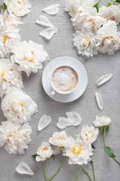 Vertical flat lay of a coffee cup with white peony flowers Stock Photos