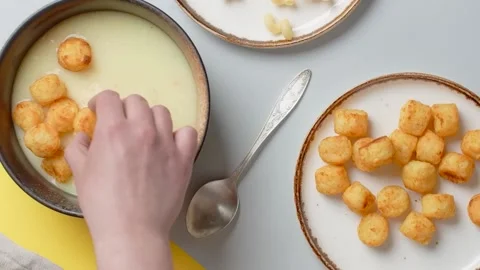 Vertical flat lay food video: the cook adds fried potato balls to the puree soup Stock Footage 184447269