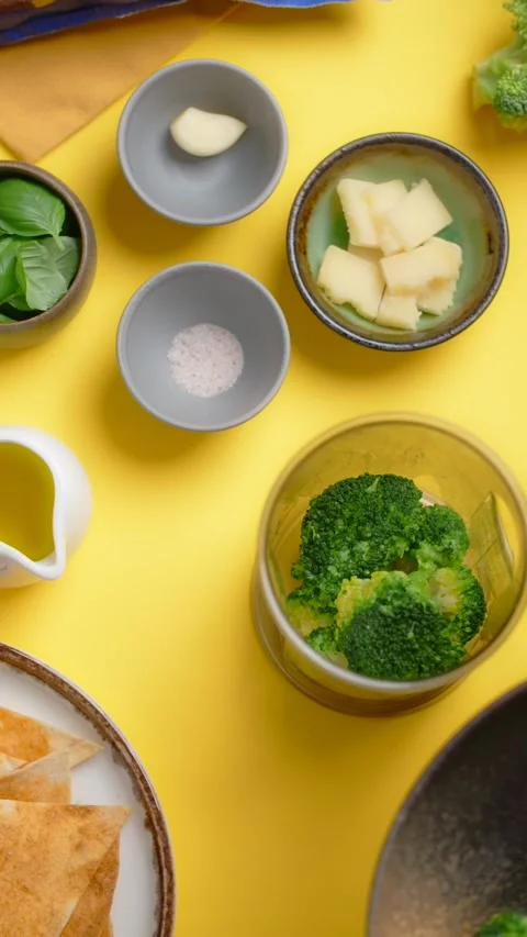 Vertical flat lay video: chef adds broccoli to the blender bowl, cooking with Stock Footage 178997043