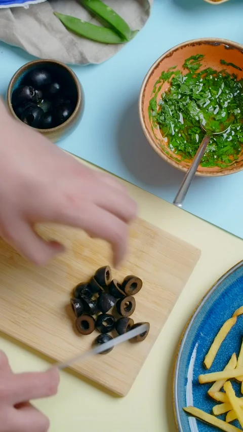 Vertical flat lay video: chef cuts the olives, tabletop recipes Stock Footage 179389574