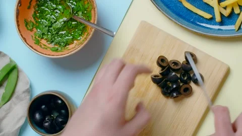Vertical flat lay video: chef cuts the olives, tabletop recipes Stock Footage 180572146