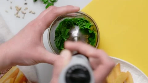 Vertical flat lay video: chef blends parsley and sunflower seeds by blender Stock Footage 180577709