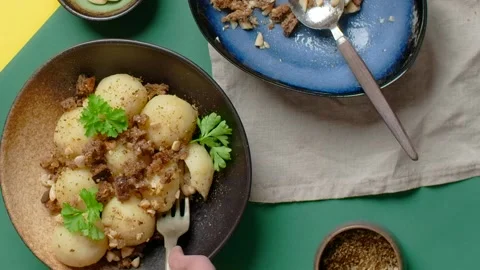 Vertical flat lay video: chef breaks a meat-filled potato dumpling with a fork Stock Footage 180945396