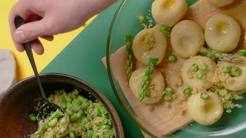 Vertical flat lay video: the cook ads chopped asparagus to the plate of cooked Video stock 183884111