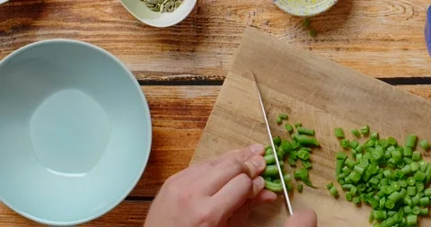 Vertical flat lay video: the cook cuts raw green beans on the wooden board Stock Footage 215690927