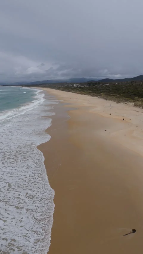 Vertical flight along a vast empty white sand beach, East Coast Tasmania. Stock-Footage 332542519