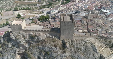 Vertical flight over Romanesque castle with flags on top of a rock Stock Footage 209996157