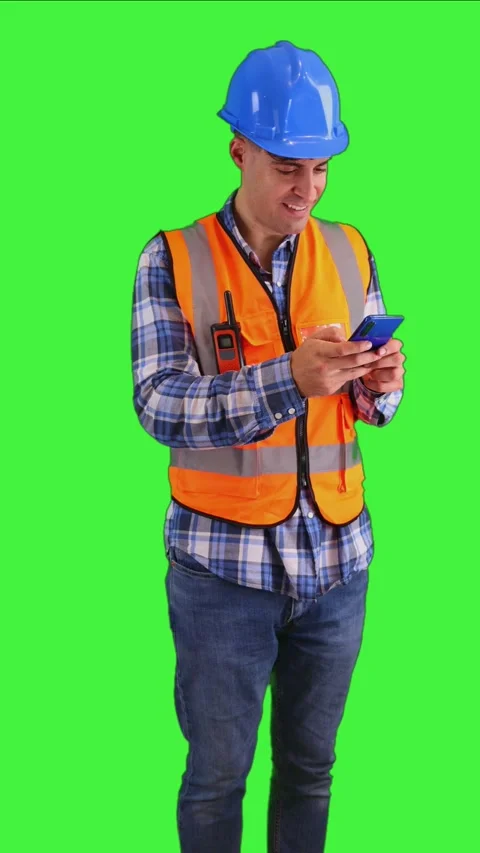 Vertical Focused construction worker texting on smartphone, wearing orange .. Stock Footage 287328041