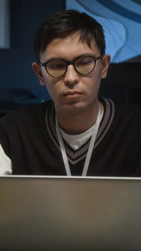 Vertical of Focused Young Project Manager Working on Laptop in Dimly Lit Office Stock Footage 329617395