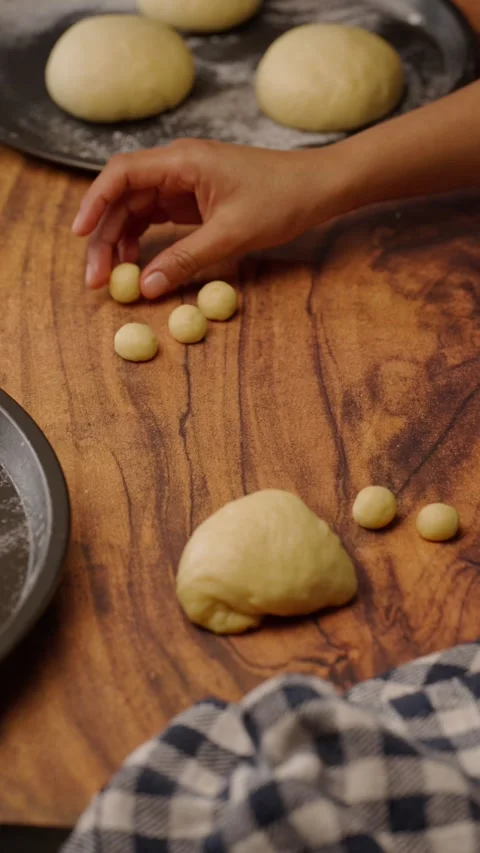 Vertical food video, rolling yeast dough to make traditional pan de muerto Stock Footage 282499565