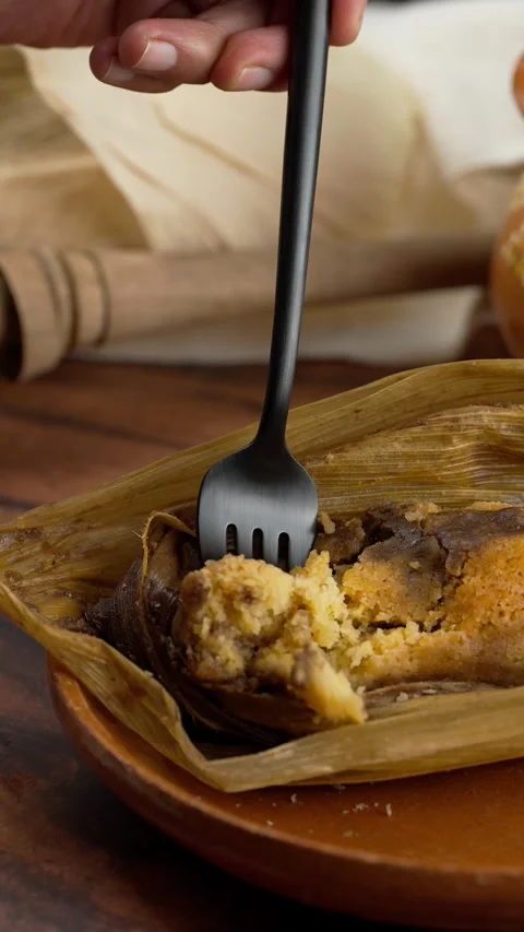 Vertical food video, someone taking a piece of mole tamale with a fork Stock Footage 280597820