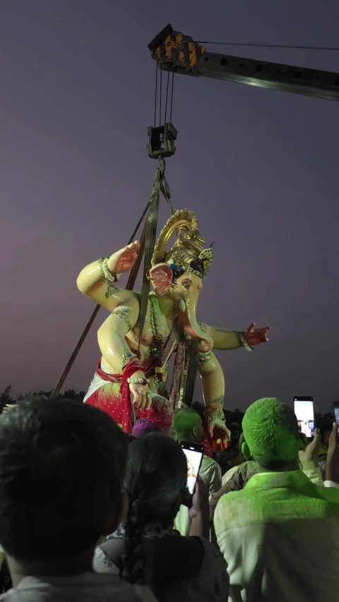 Vertical footage of Big statue of Lord Ganesha Visarjan with Heavy-duty cranes. Stock Footage 346395950