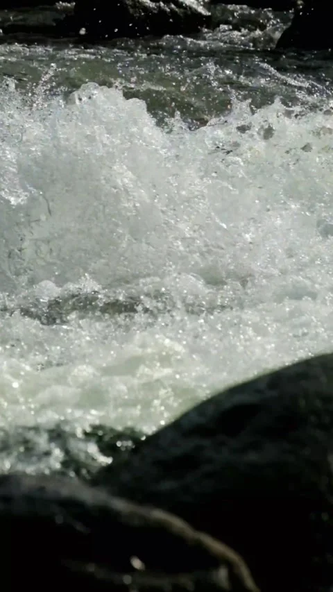 Vertical footage of a clear mountain river flowing rapidly through river rocks Stock-Footage 320922380