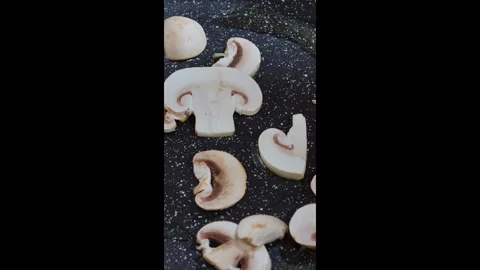 Vertical footage. The cook puts raw mushrooms in a hot pan. Slow motion video. Stock Footage 302649062